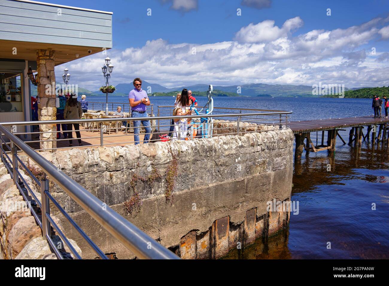 Les gens qui profitent du soleil sur les rives du Loch Lomond au café de Duck Bay Marina Banque D'Images