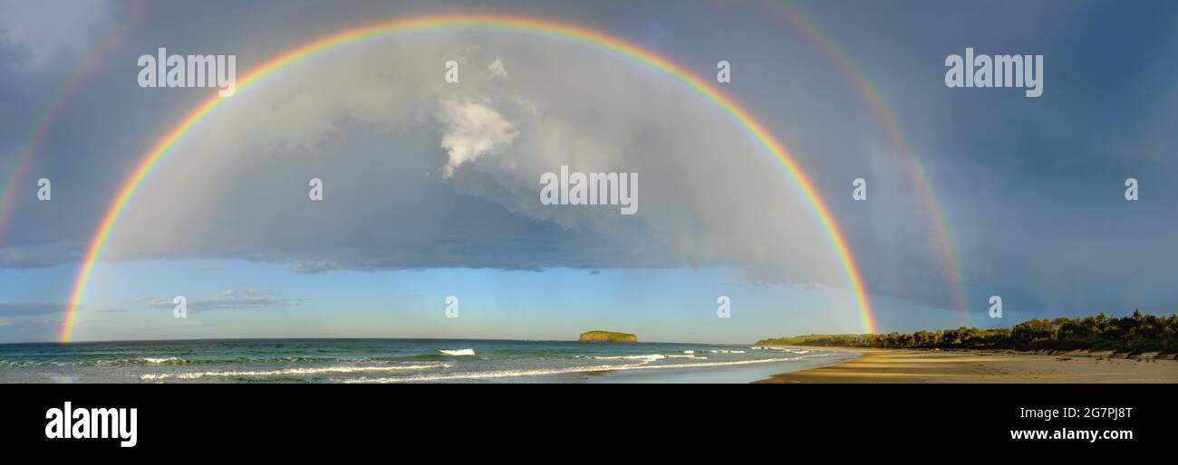 Vue panoramique sur Mystics Beach, Killalea, Nouvelle-Galles du Sud d'un double arc-en-ciel pendant la douche à effet pluie d'hiver Banque D'Images