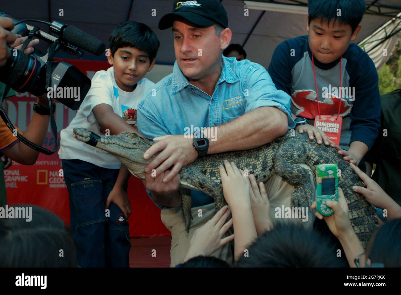 Bogor, Java-Ouest, Indonésie. 26 juillet 2006. L'Herpétologue Brady Barr tient un jeune crocodile pour permettre aux enfants de toucher le reptile, au cours d'un événement visant à promouvoir « rencontres dangereuses : Brady's Croc Adventure », une émission télévisée éducative diffusée sur la chaîne géographique nationale. L'événement se tient au Taman Safari Indonésie à Cisarua, Bogor, West Java, Indonésie. Banque D'Images