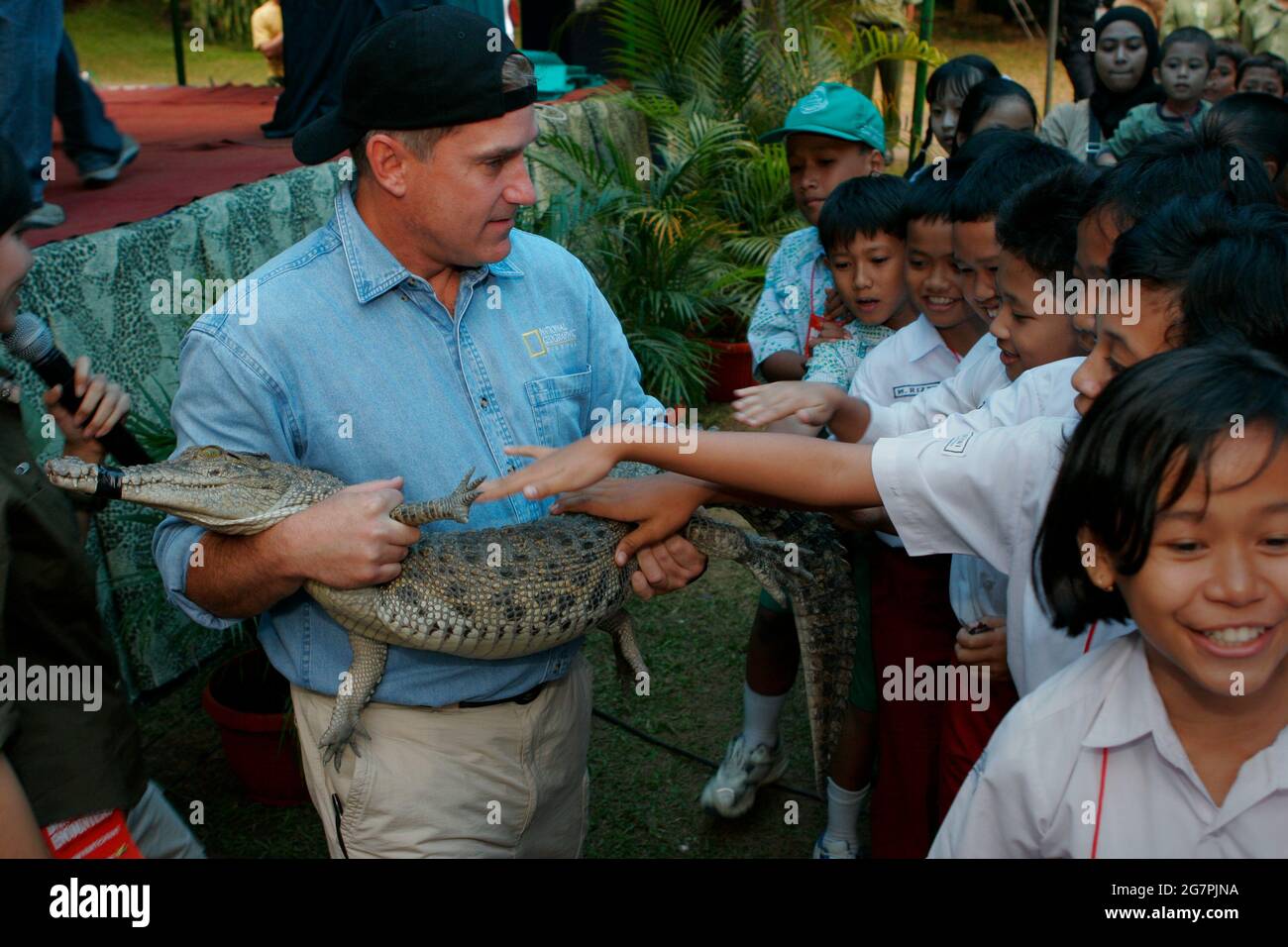 Bogor, Java-Ouest, Indonésie. 26 juillet 2006. L'Herpétologue Brady Barr tient un jeune crocodile pour permettre aux enfants de toucher le reptile, au cours d'un événement visant à promouvoir « rencontres dangereuses : Brady's Croc Adventure », une émission télévisée éducative diffusée sur la chaîne géographique nationale. L'événement se tient au Taman Safari Indonésie à Cisarua, Bogor, West Java, Indonésie. Banque D'Images