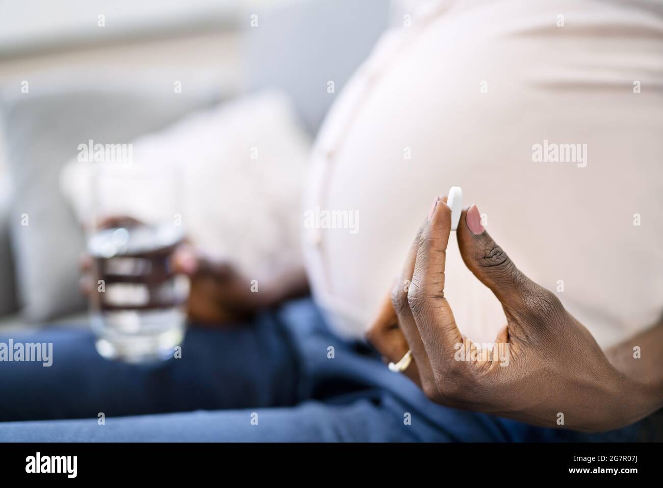 Femme africaine enceinte prenant des médicaments de pilule acide Banque D'Images