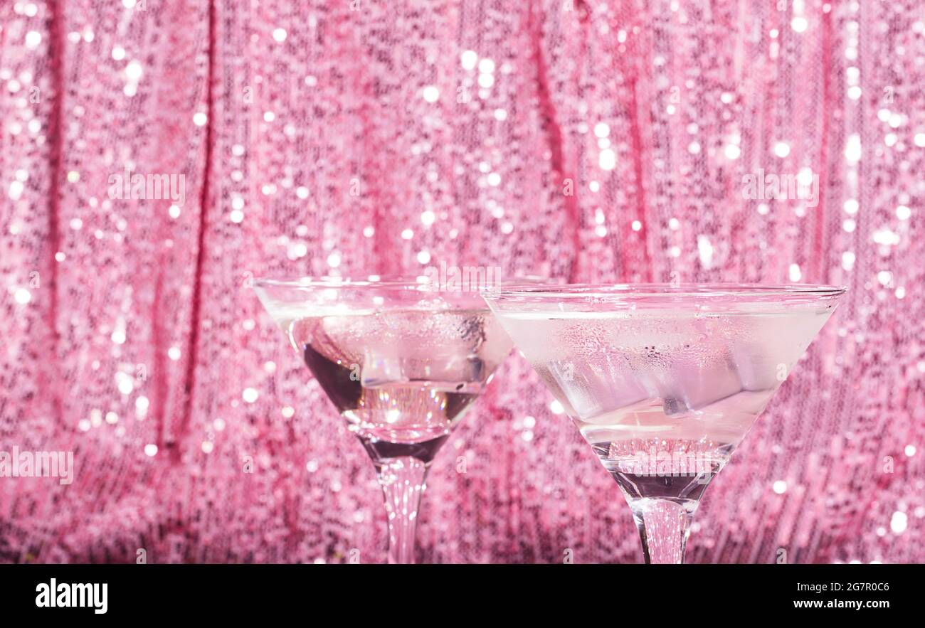 Décor cocktail Martini, rideau rose brillant. Boisson alcoolisée classique avec glace dans un verre élégant pour la fête Banque D'Images