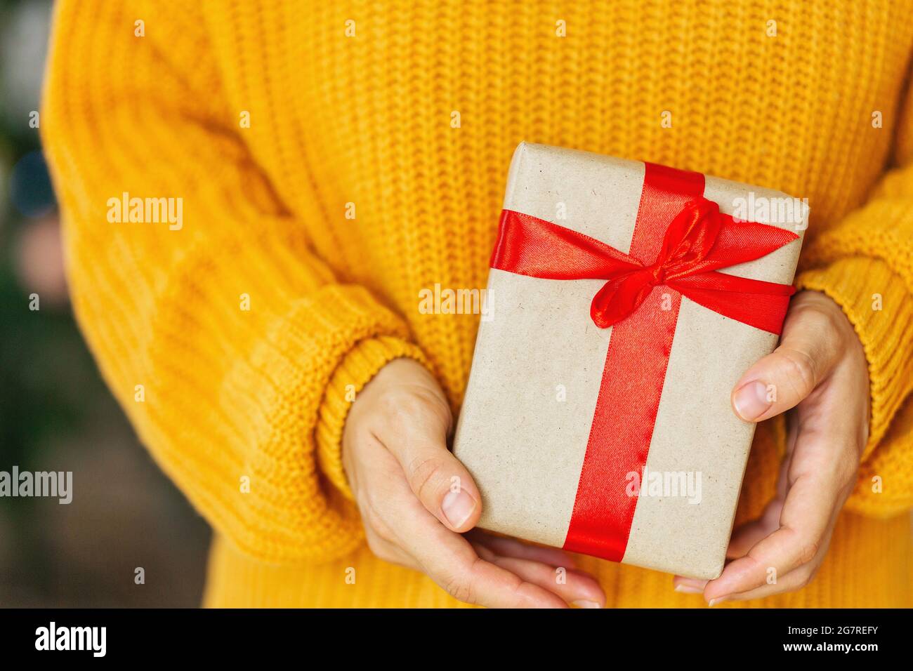 Femme en pull jaune confortable donnant des boîtes-cadeaux de noël  artisanales avec ruban rouge. Don de cadeaux concept.Valentine jour et de  la fête des mères concept cadeau Photo Stock - Alamy