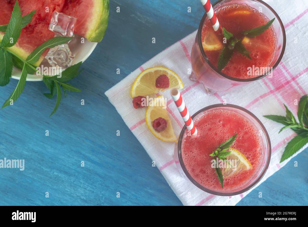 Jus de pastèque frais avec framboises et citron dans un verre. Tranches de pastèque et de framboises sur la table. Vue de dessus. Le concept de nutr naturel Banque D'Images