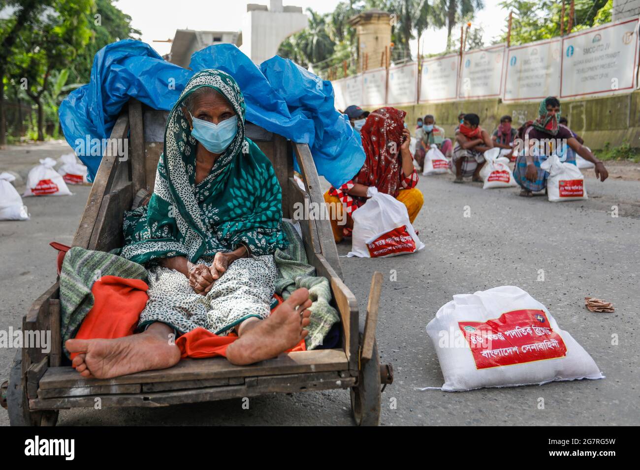Les personnes à faible revenu reçoivent des produits alimentaires d'urgence fournis par l'armée du Bangladesh pendant l'isolement national afin de freiner la propagation du coronavirus (COVID-19) Banque D'Images