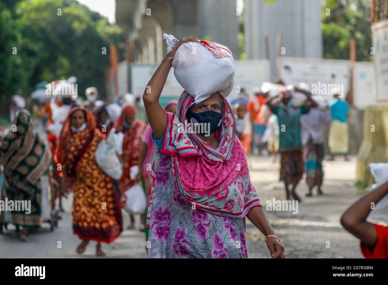 Les personnes à faible revenu reçoivent des produits alimentaires d'urgence fournis par l'armée du Bangladesh pendant l'isolement national afin de freiner la propagation du coronavirus (COVID-19) Banque D'Images
