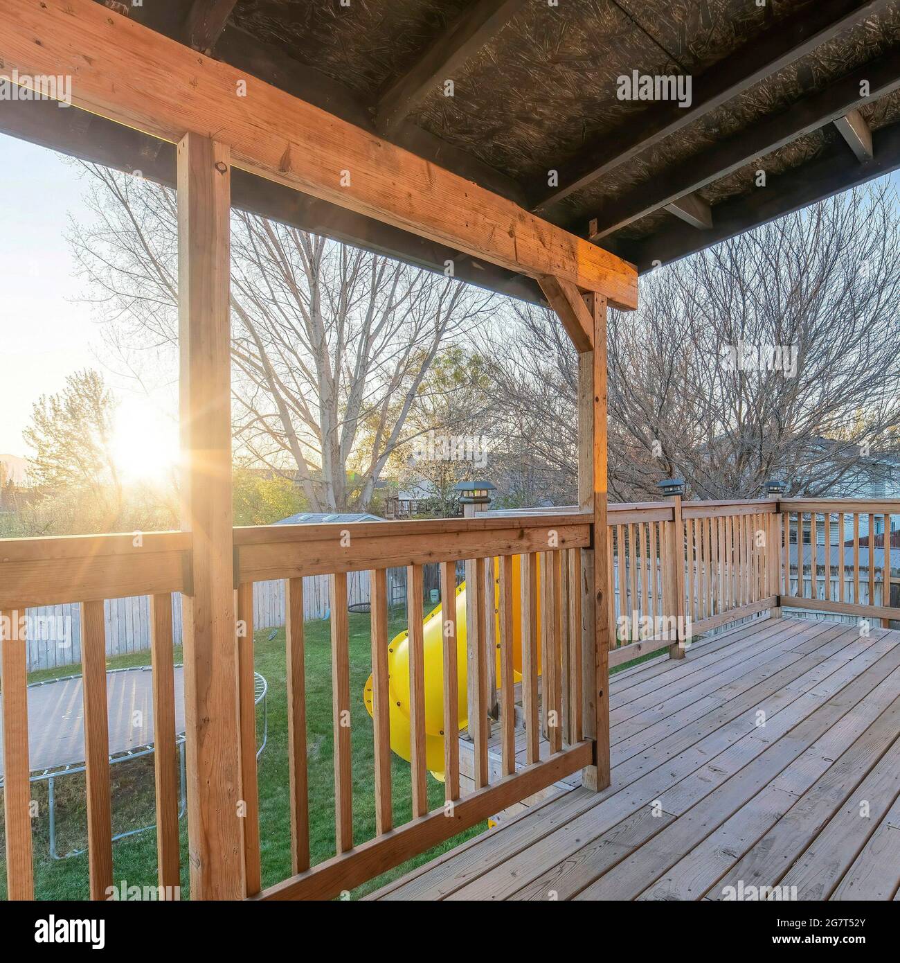 Cadre carré terrasse en bois de la maison avec glissoire jaune descendant  vers la cour avec trampoline Photo Stock - Alamy