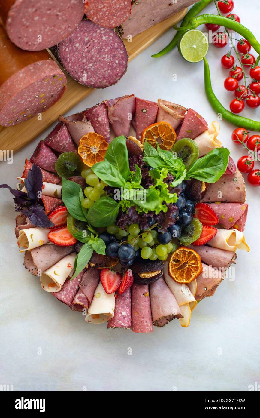 Assiette à viande sur fond de bois blanc. Ensemble de salami. Coupes froides de différents types de viande. Plateau de set antipasti. Plat de collation à la viande. Vue de dessus Banque D'Images