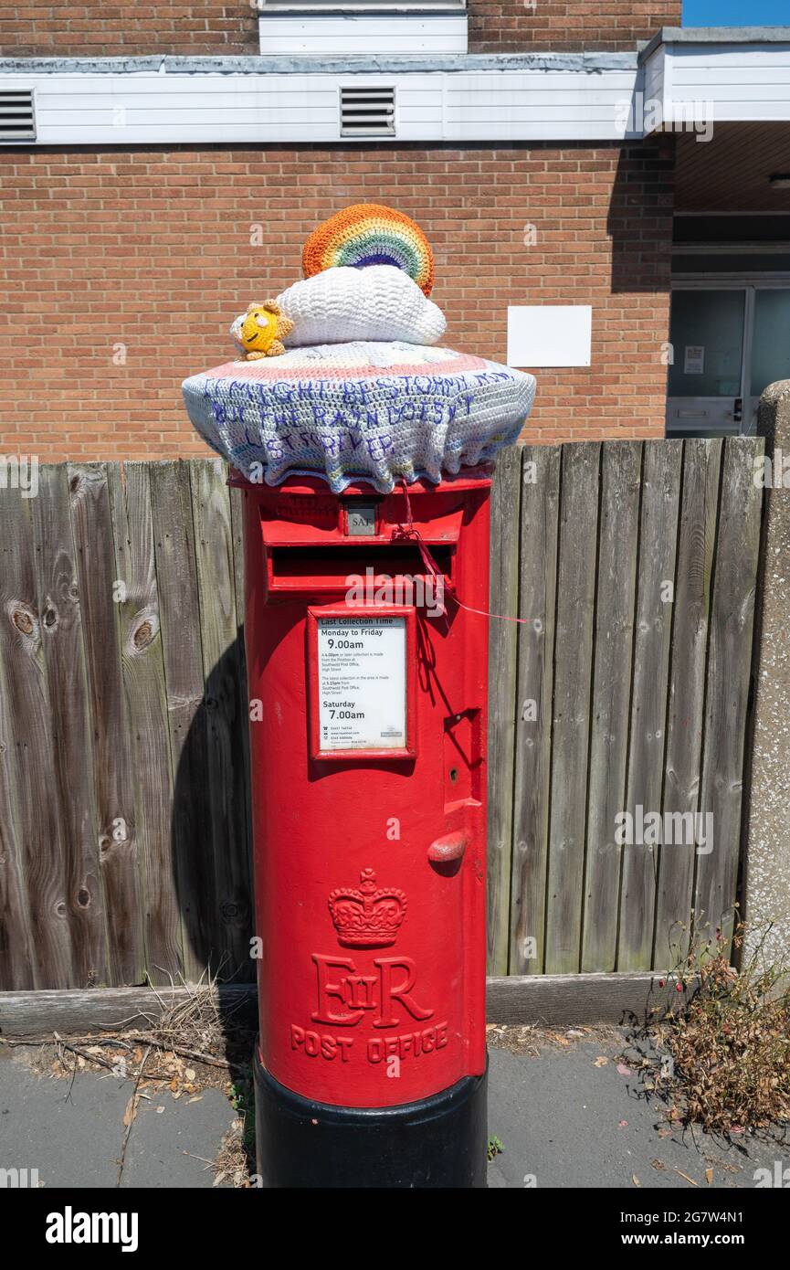Les boîtes postales rouges Royal Mail avec des hauts en laine tricotés à la main en appréciation des principaux travailleurs à travers la pandémie de Covid 19 Banque D'Images