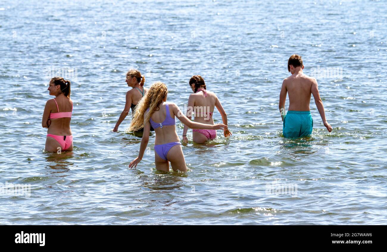 Dundee, Tayside, Écosse, Royaume-Uni. 16 juillet 2021. Météo au Royaume-Uni : temps chaud et ensoleillé qui traverse le nord-est de l'Écosse avec une température maximale de 29 °C. Les amateurs de plage prennent la journée en profitant du soleil d'été le long de la plage de Broughty Ferry à Dundee. Cinq jeunes jouent dans l'eau avant d'aller nager dans la rivière Tay. Crédit : Dundee Photographics/Alamy Live News Banque D'Images