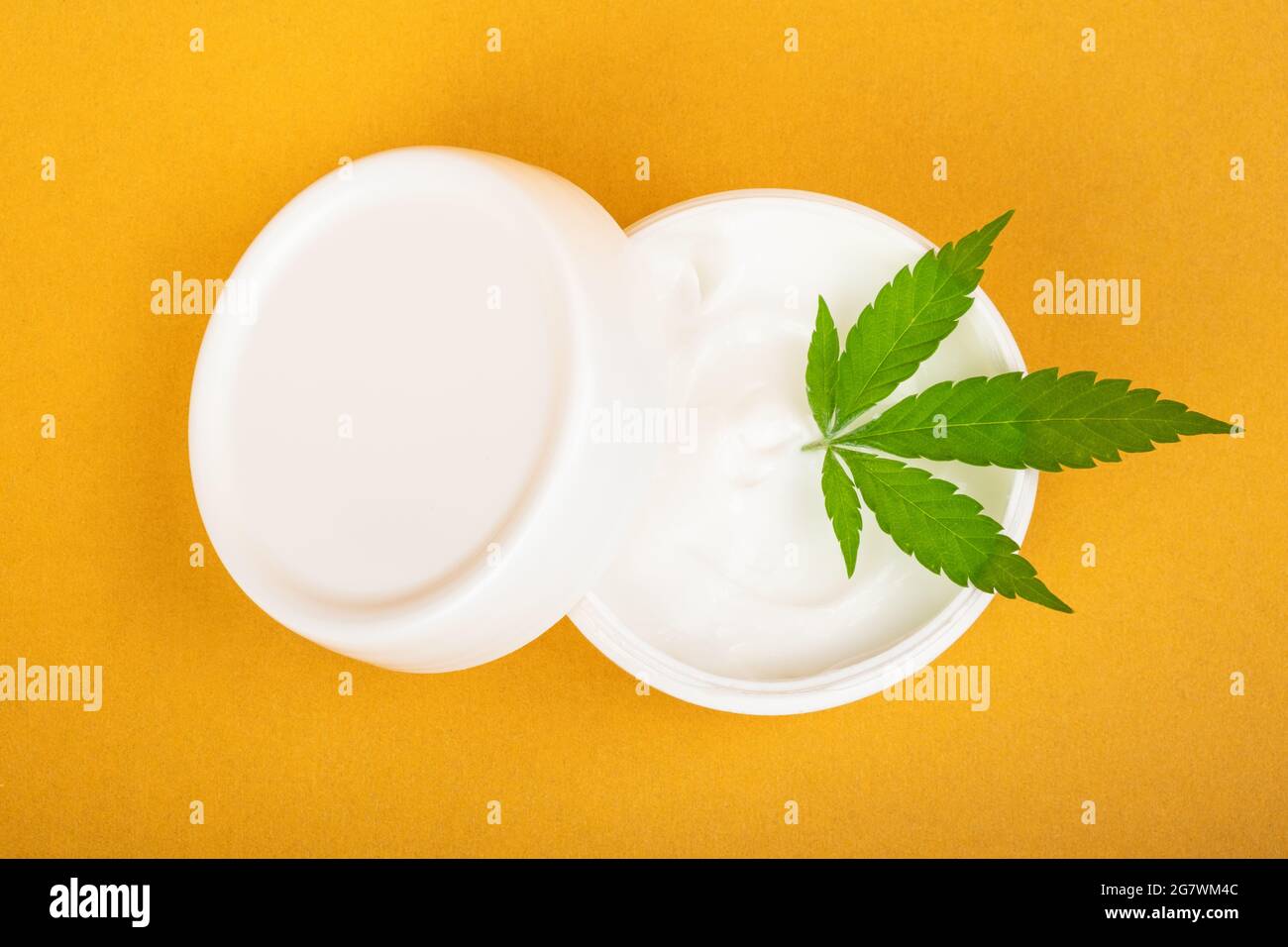 crème cosmétique pour combattre les rides sur la peau avec du cannabis sur fond jaune. Banque D'Images