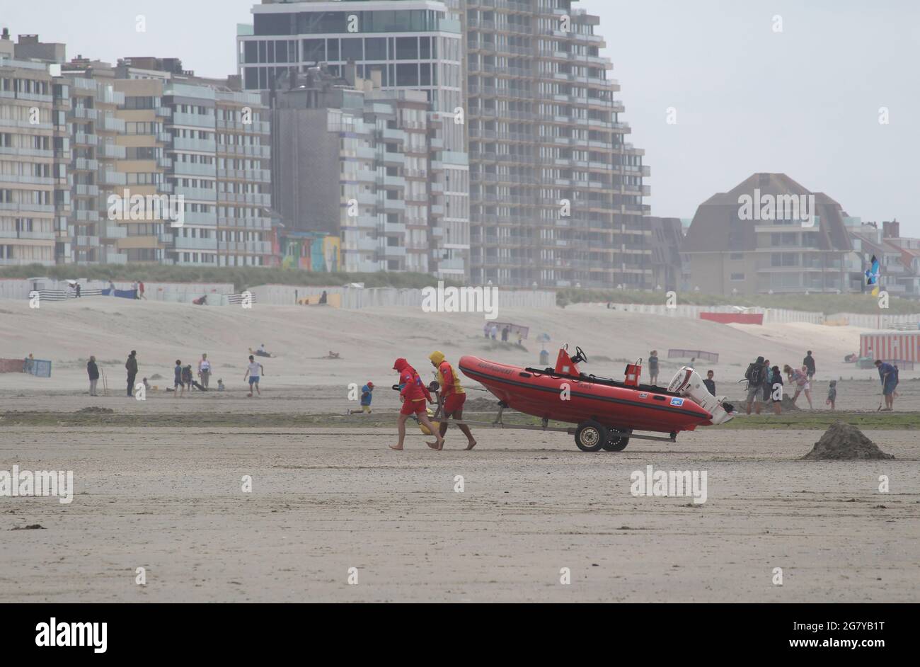 NIEUWPOORT, BELGIQUE, 15 JUILLET 2021 : sauveteurs sur la plage, déplaçant un bateau de sauvetage, lors d'une journée d'été chargée à Nieuwpoort, Flandre Occidentale. Nieuwpoort est un Banque D'Images