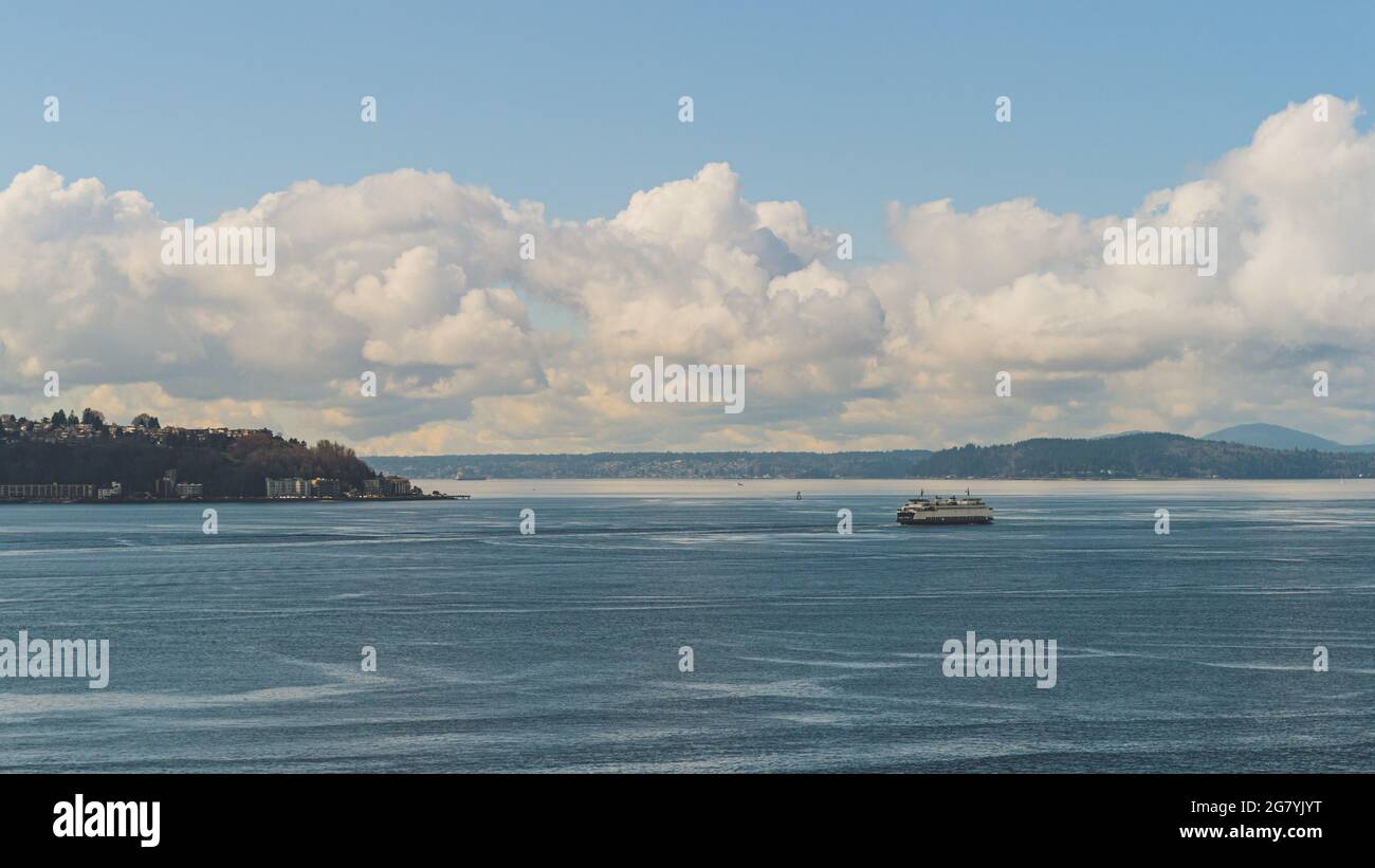 Le Washington Ferry navigue sur Elliot Bay en passant par l'ouest de Seattle et le ciel de Cloud Banque D'Images