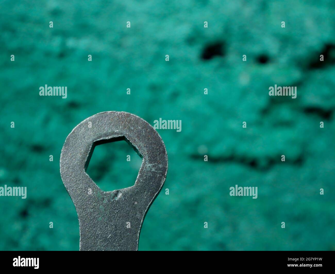 Outil de fermeture à vis à main en métal présenté sur fond flou pour l'affichage industriel. Banque D'Images