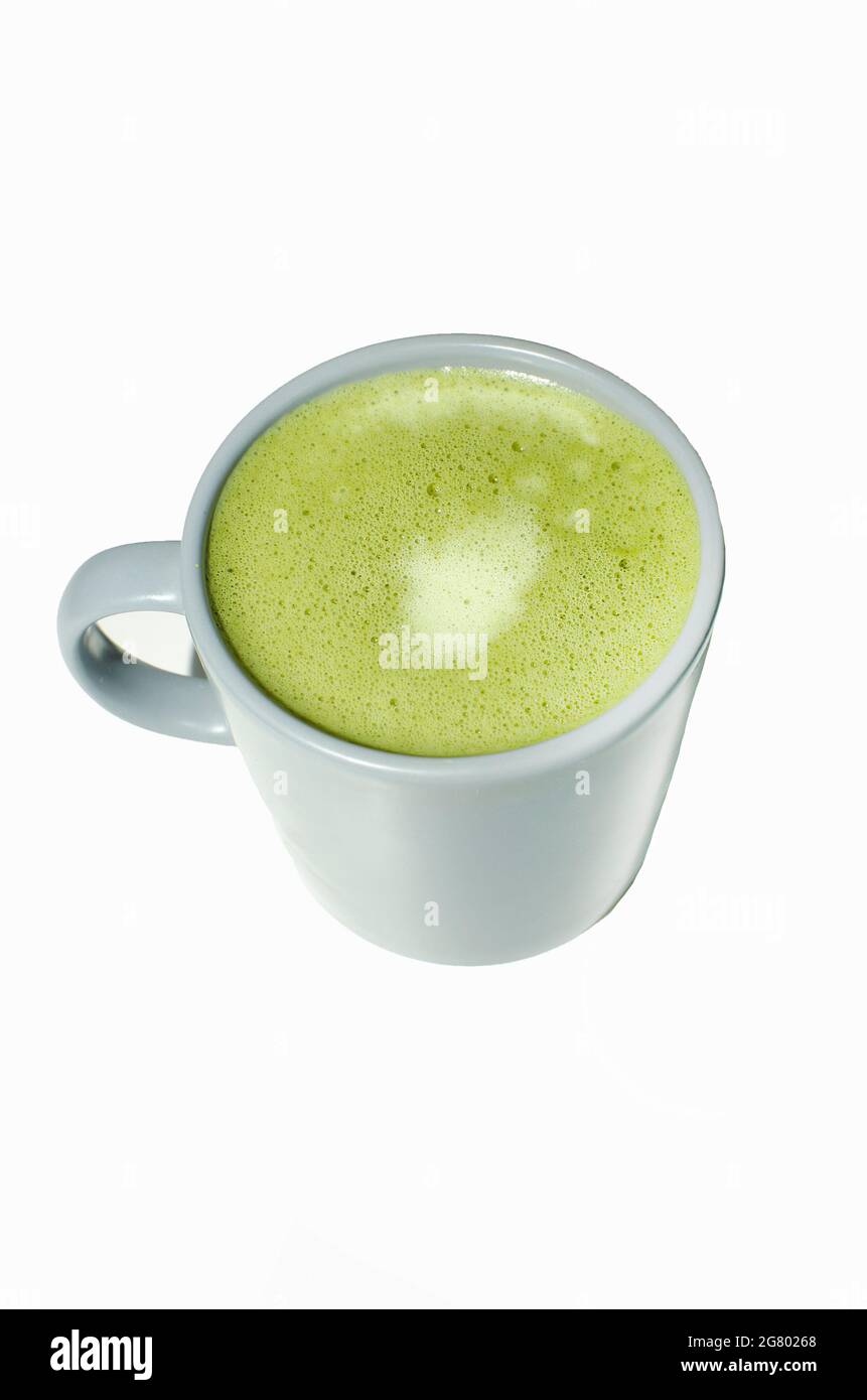 Matcha, thé vert latte dans une tasse. Fond blanc isolé. Gros plan. Vue de dessus. Banque D'Images