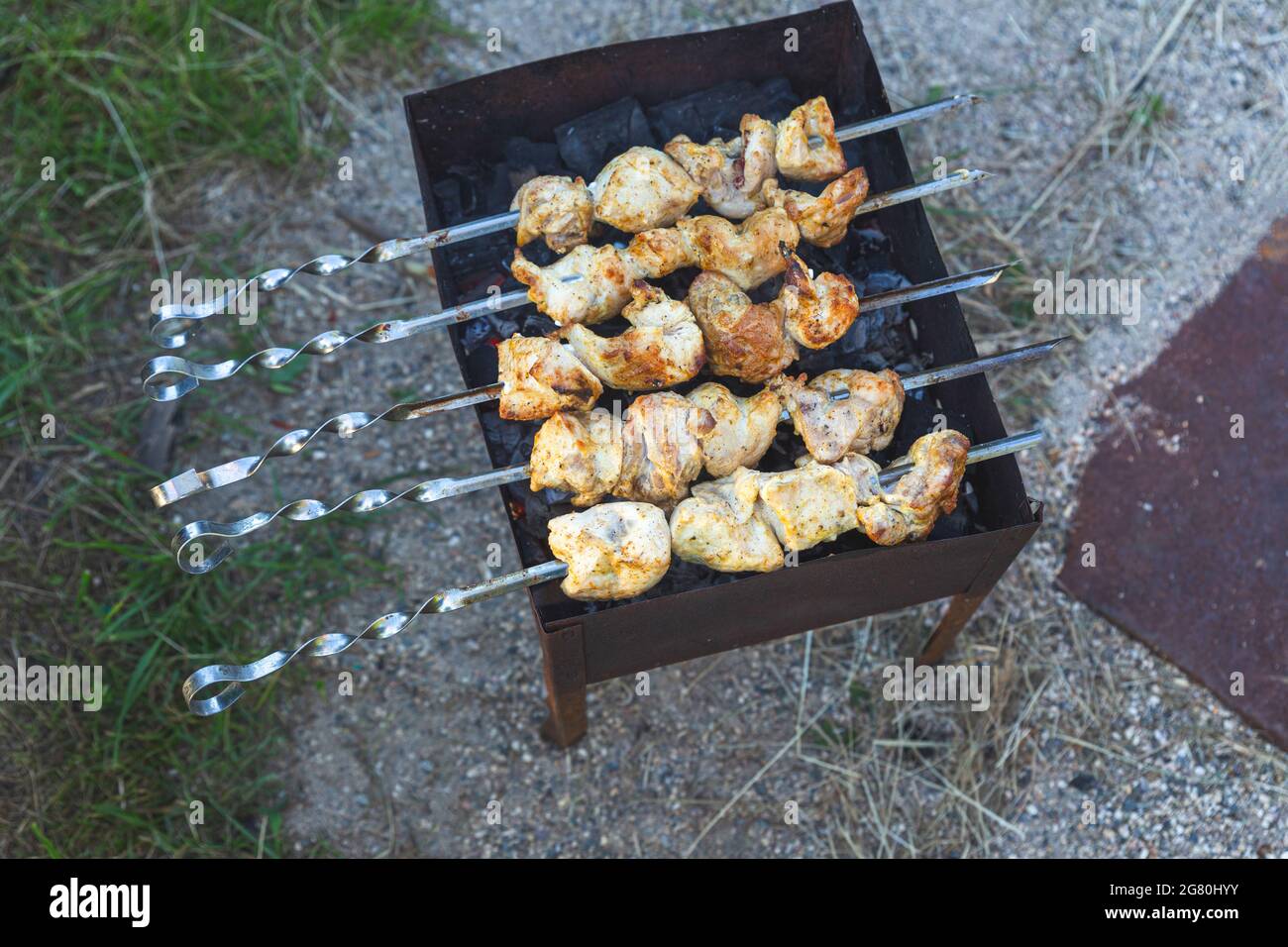 La viande brossée est frite sur charbon de bois sur un grill ou un brazier, vue de dessus. Pique-nique, soirée entre amis et en famille, cuisine sur un feu ouvert à l'avant ou Banque D'Images