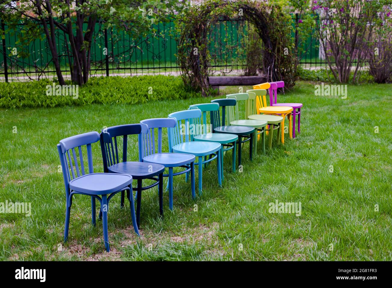 Chaises viennoises en bois repeintes et rénovées, chaises colorées sur la pelouse comme symbole de consommation consciente des choses Banque D'Images