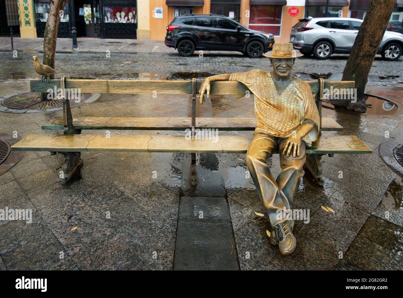 Statue du compositeur portoricain Tite Curet Alonso assis sur un banc sur la Plaza de Armas, Old San Juan, Puerto Rico, Etats-Unis. La statue de Luz Badillo. Banque D'Images