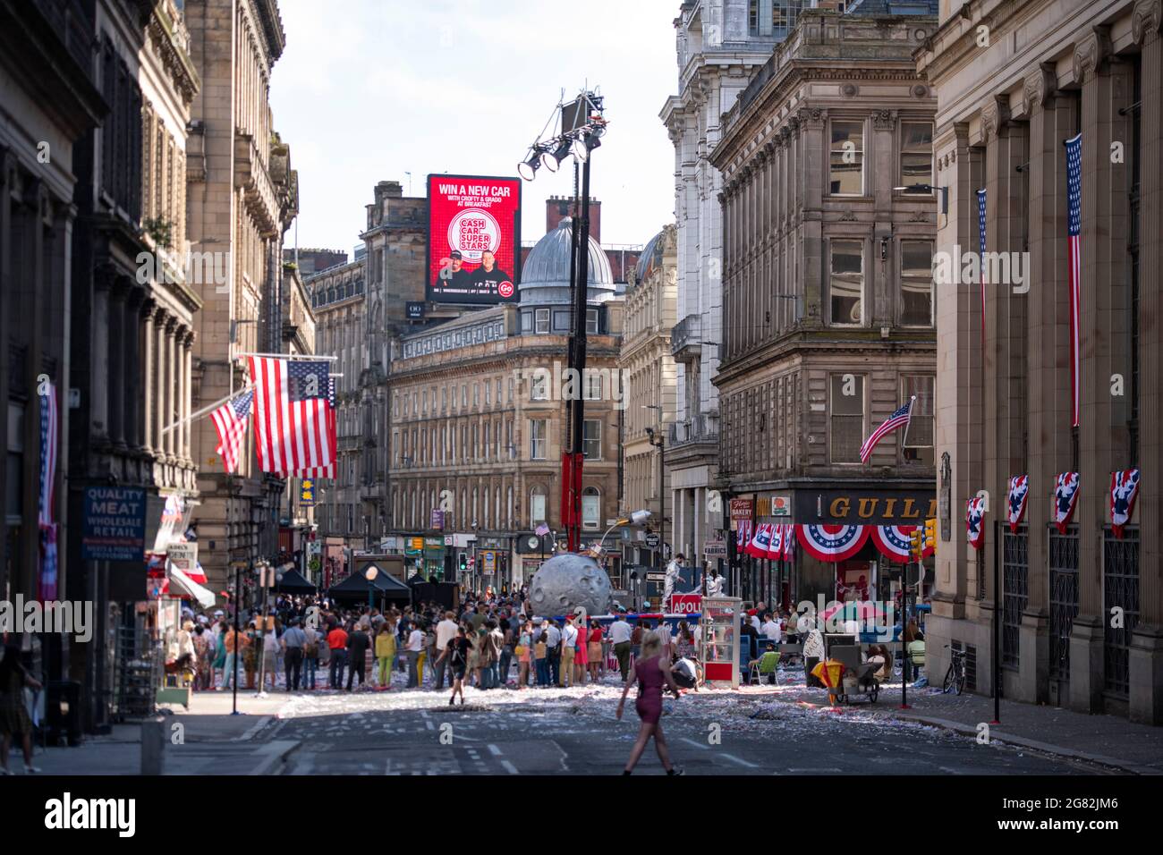 Glasgow, Écosse, Royaume-Uni. 16 juillet 2021. PHOTO : jour 4 du tournage du film hollywoodien à succès d'Indiana Jones 5. Les scènes d'aujourd'hui disent une parade de ticker avec des bandes de marchage, des foules de foudroyantes, la presse et les astronautes de retour dans une scène américaine de New York 1959. Les rues sont décorées d'étoiles et de bandes drapeaux et de banderoles et le Harrison Ford double a été vu à cheval de retour dans les rues de Glasgow. Crédit : Colin Fisher/Alay Live News Banque D'Images