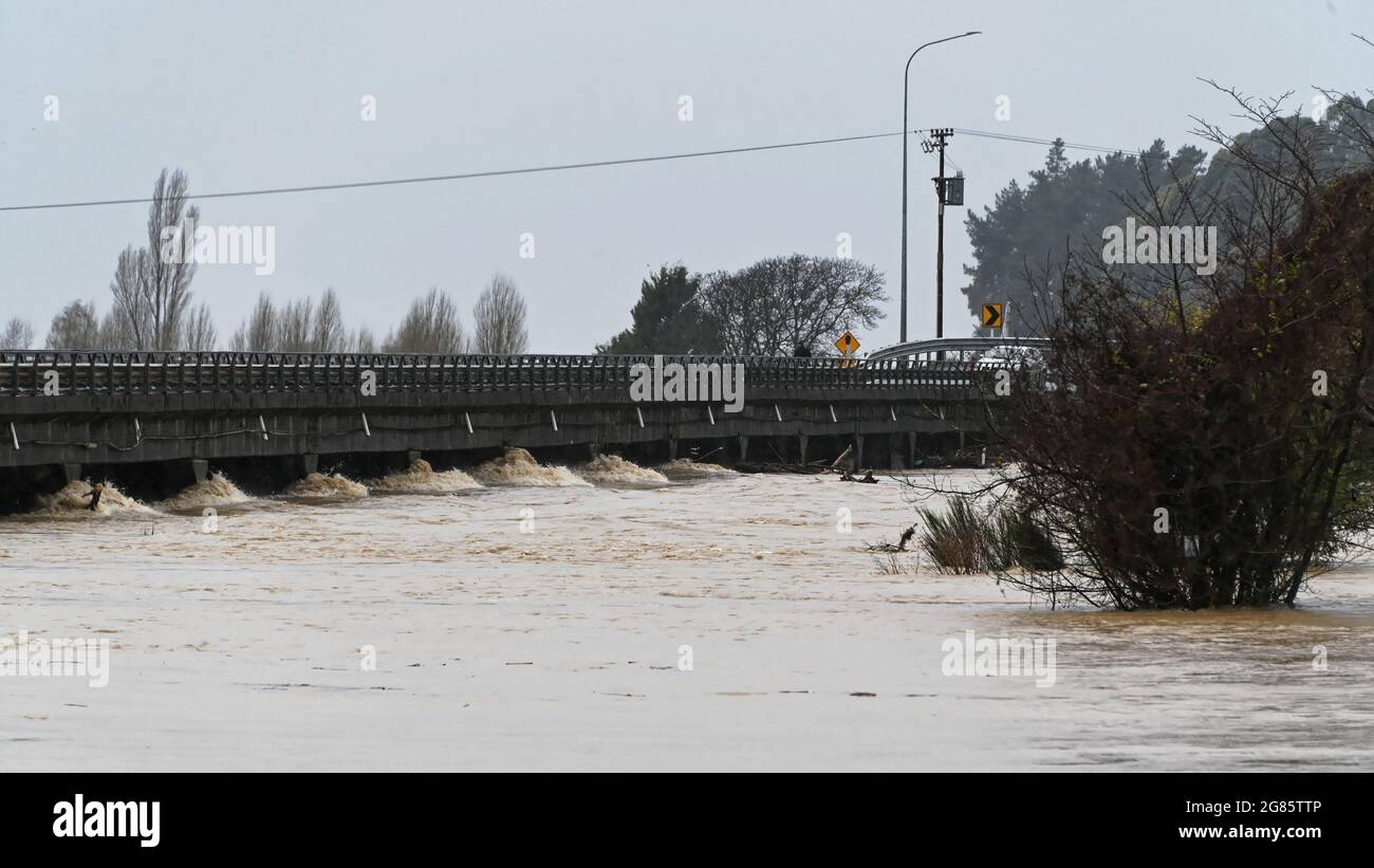 INONDER LES EAUX SOUS LE PONT DE MOTUEKA. Motueka, Nouvelle-Zélande 17 juillet 2021. La rivière Motueka s'écoule sous le pont de Motueka dans un torrent boueux après une pluie torrentielle qui a causé des inondations généralisées en Nouvelle-Zélande. © Anne Webber / Alamy Live News Banque D'Images