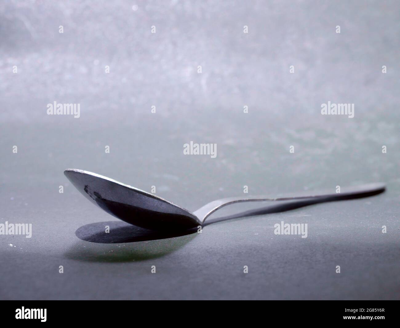 Cuillère simple en acier inoxydable isolée sur fond gris, image de la coutellerie de cuisine. Banque D'Images