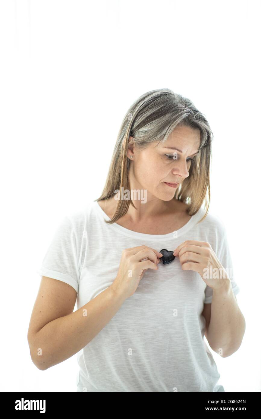femme d'âge moyen avec cristal en forme de coeur. Concept d'amour de soi Banque D'Images