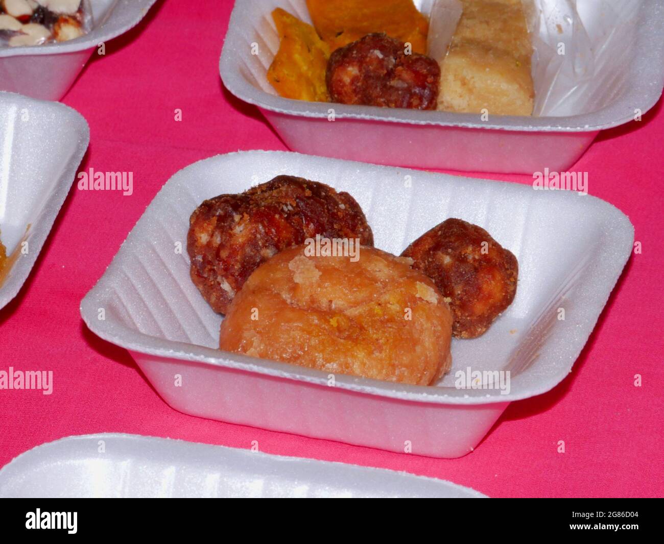 Jaggery fait indien traditionnel brun sucré présenté avec biscuit de cuisson sur plaque blanche. Banque D'Images