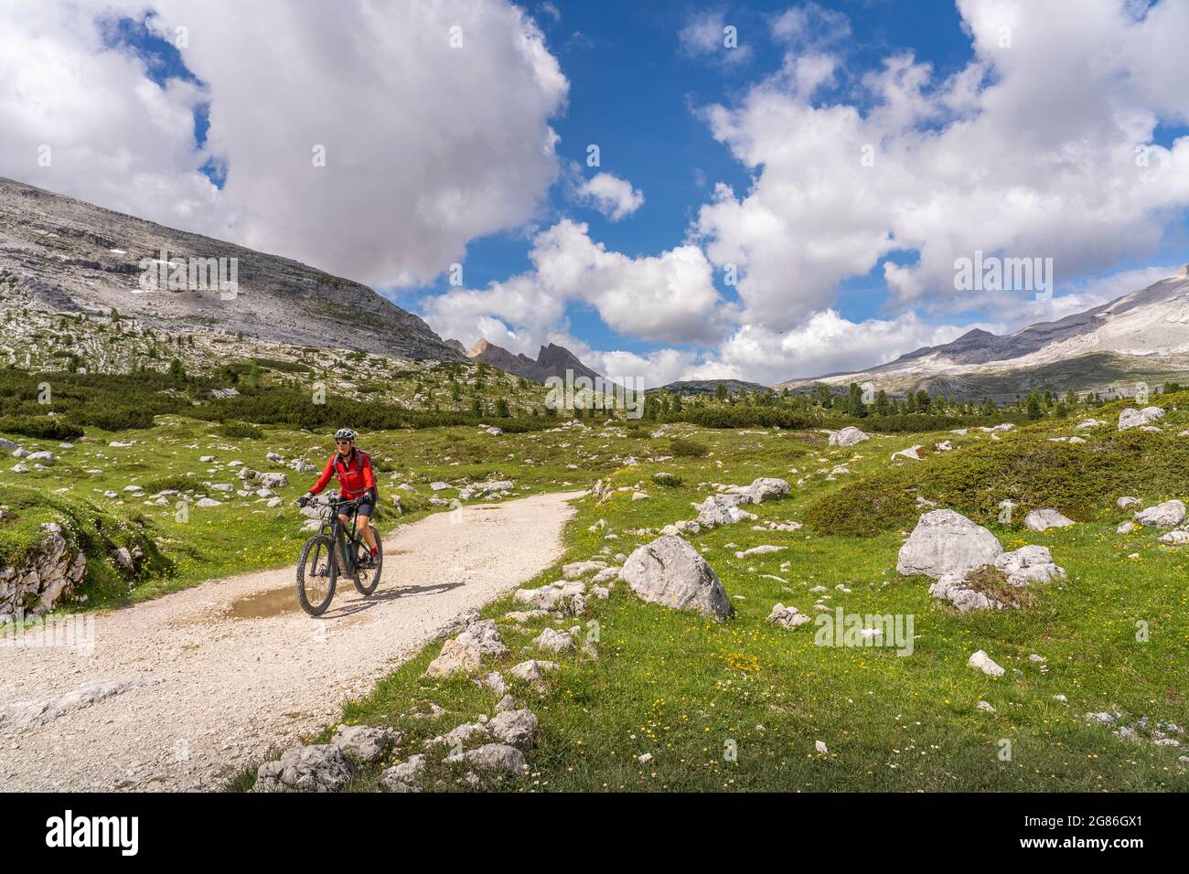 Jolie femme sénior très active à vélo électrique dans la haute vallée de Fanes, une partie du parc naturel de Fanes-Sennes-Baies, Dolomites, Italie Banque D'Images