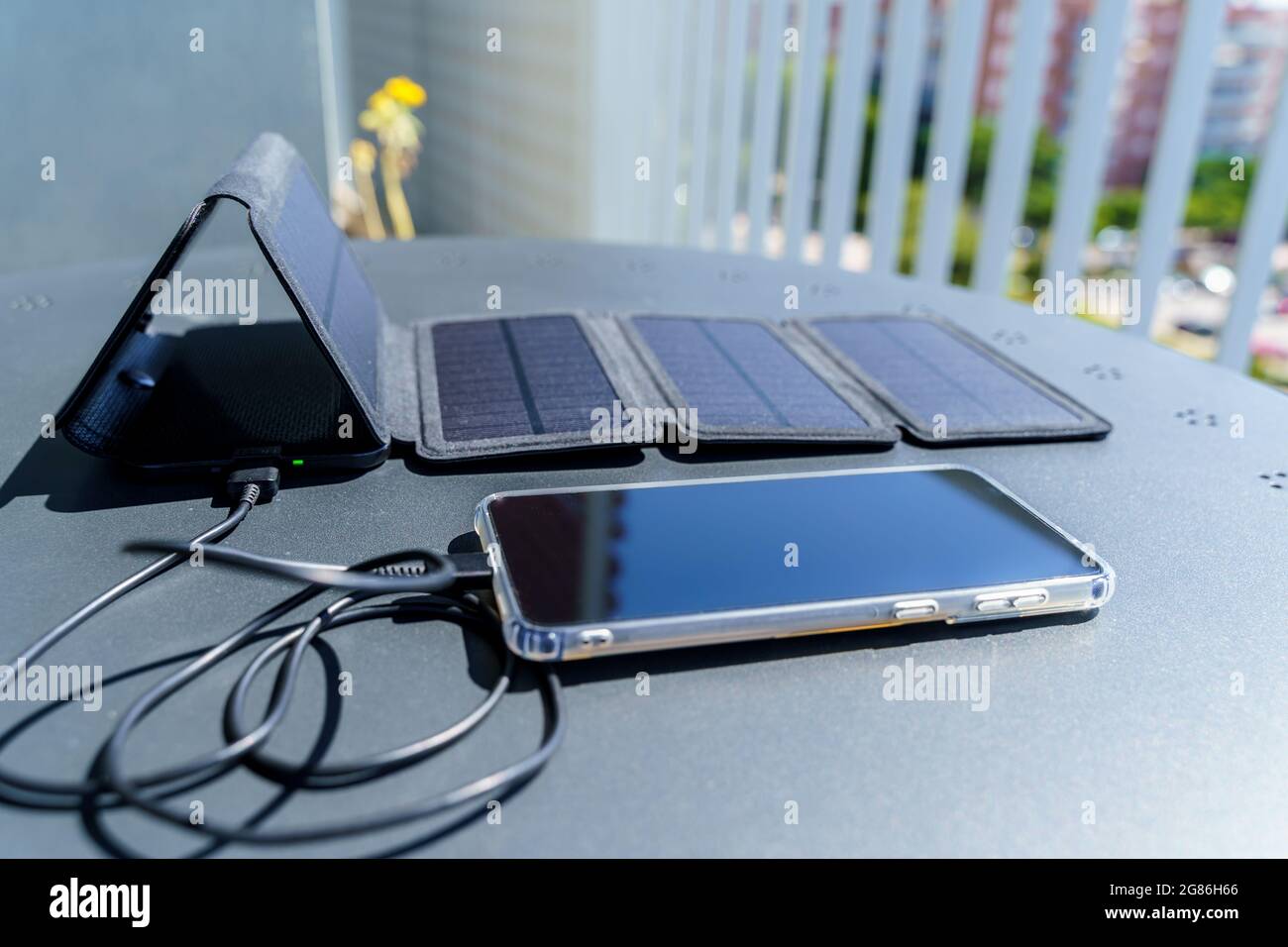 Charge d'un smartphone depuis la maison avec un chargeur portable pour panneau solaire.consommation et charge avec de petits panneaux solaires i Banque D'Images