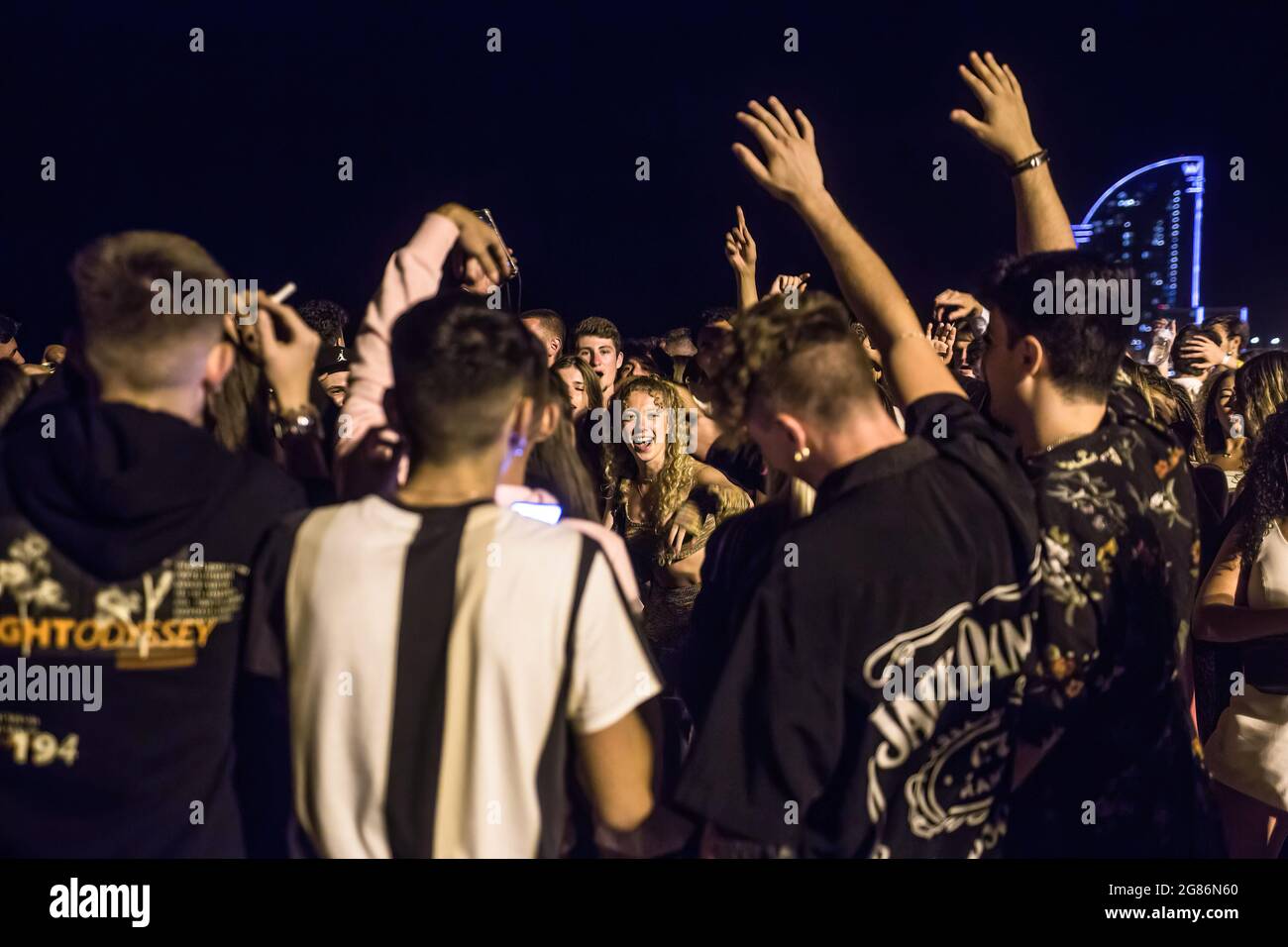 Barcelone, Espagne. 16 juillet 2021. Une foule de jeunes est vue sur la plage de Barceloneta en face de l'Hôtel W Barcelona. La police expulse les foules de la plage de Barceloneta après que la Catalogne ait décrété le retour du couvre-feu étant donné le rebond dans les cas de COVID-19 en raison de la variante delta du coronavirus. Le couvre-feu doit commencer à 1 h 00 le 17 juillet. Crédit : SOPA Images Limited/Alamy Live News Banque D'Images