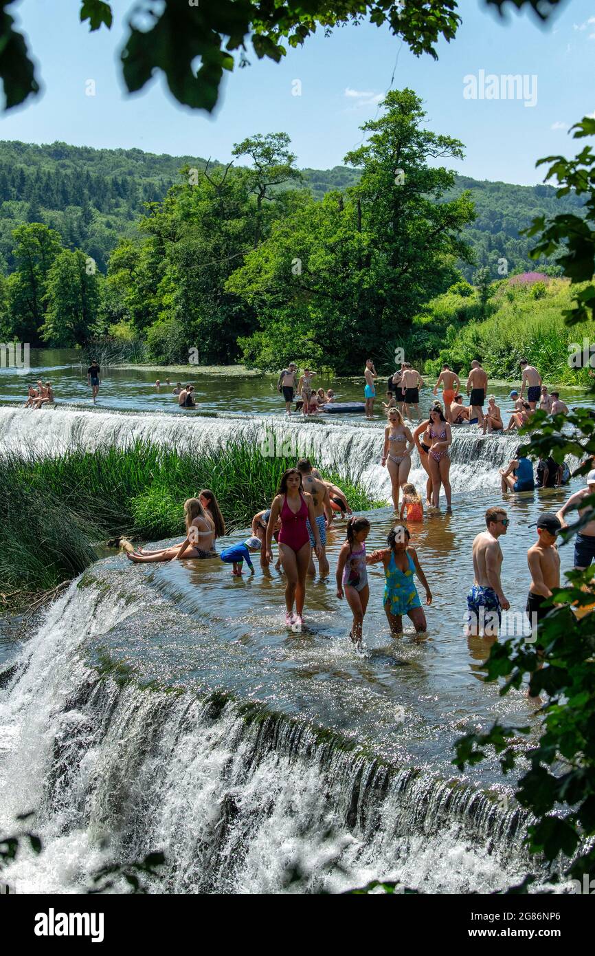 Les gens apprécient l'eau à Warleigh Weir sur la rivière Avon près de Bath dans Somerset tandis que les températures montent à travers le Royaume-Uni. Banque D'Images