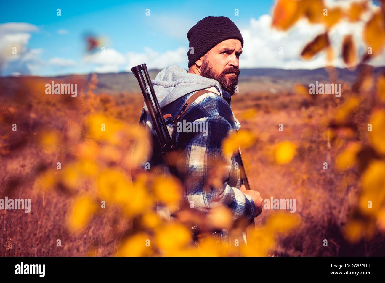 Saison de chasse en automne. Chasseur avec fusil de chasse. Recherche automatique. Poacher avec Rifle trating certains Deers. Gros plan Portrait d'un chasseur de hamdsome. Banque D'Images