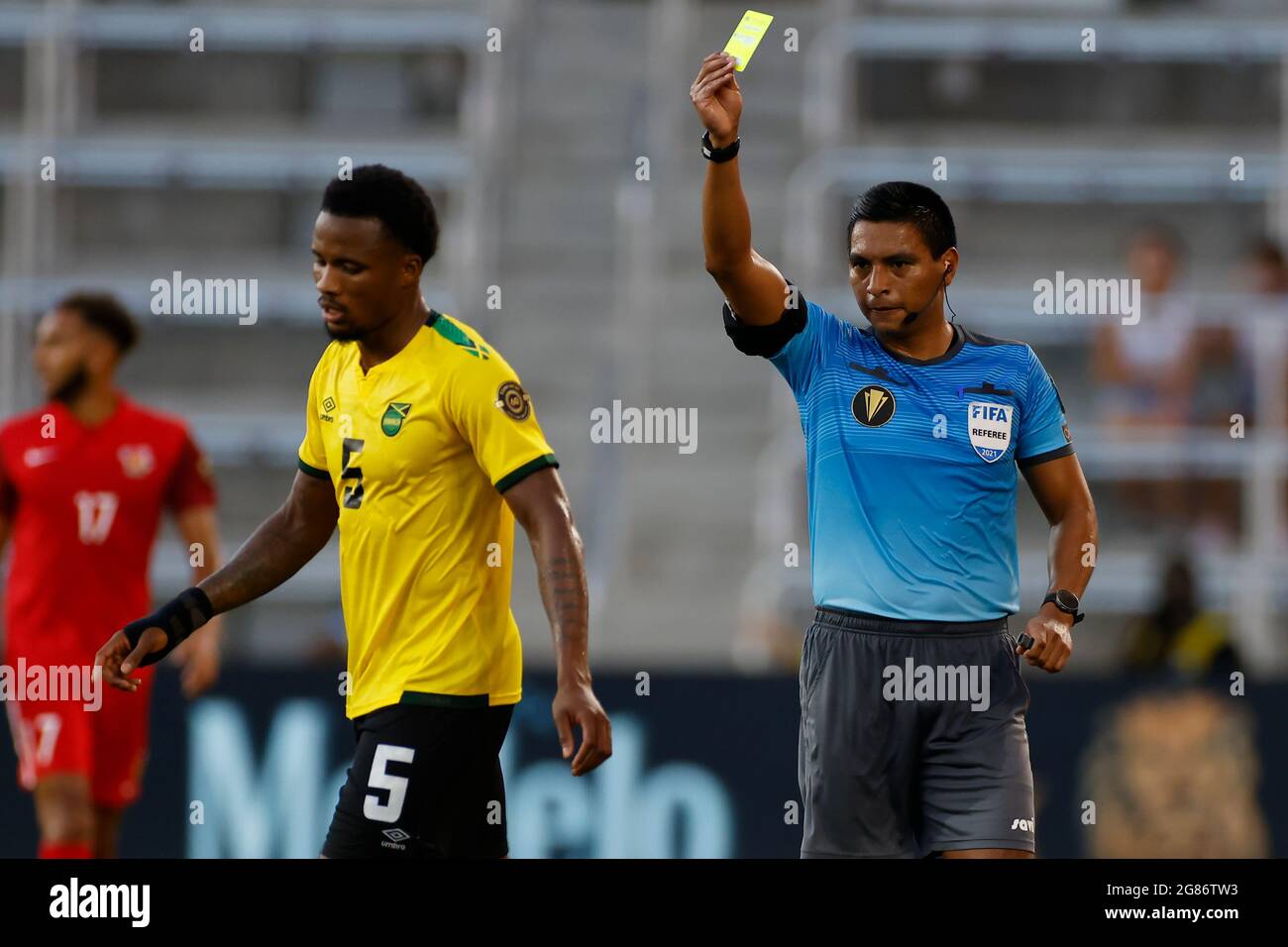 Orlando, Floride, États-Unis. 16 juillet 2021. L'arbitre Bryan Lopez montre la carte jaune au défenseur de la Jamaïque Alvas Powell lors du match de la coupe d'or CONCACAF entre la Guadeloupe et la Jamaïque le 16 juillet 2021 au stade Explora à Orlando, en Floride. Crédit : action plus Sports/Alamy Live News Banque D'Images