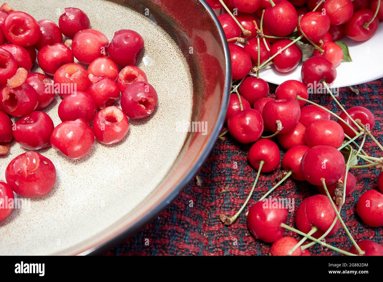 cerises fraîches et cerises dénoyautées (piquées) dans un intestin Banque D'Images