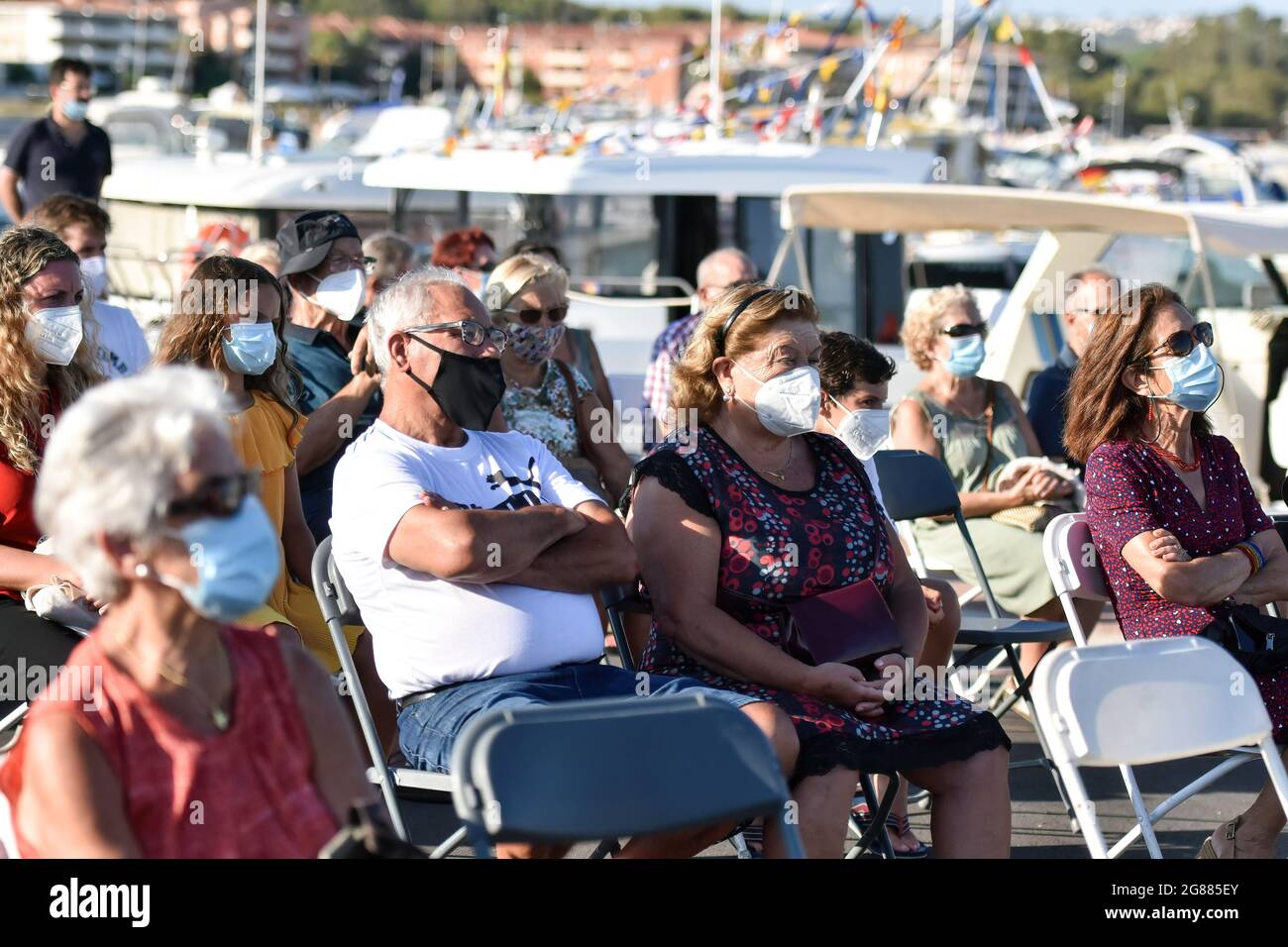 Les personnes portant un masque facial s'assoient au port de Coma-ruga pendant la procession maritime de la Virgen del Carmen à Vendrell. Chaque année, le 16 juillet, un festival religieux est célébré en l'honneur de la Virgen del Carmen, Saint patron des marins et des pêcheurs, bien que la célébration soit le 16 juillet, la procession se tient le week-end pour que plus de personnes puissent assister à la célébration. La statue de la Vierge, est portée par un groupe de personnes qui la conduit à un bateau partant pendant la procession à travers les eaux de la mer près du port suivi de plusieurs bateaux. (Photo de Ramon Costa/SOPA Images/Sipa USA Banque D'Images