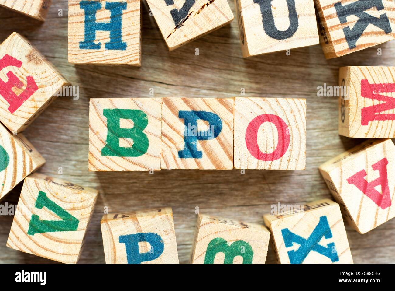 Bloc de lettres de l'alphabet dans le mot BPO (abréviation de Business Process Outsourcing) avec un autre sur fond de bois Banque D'Images