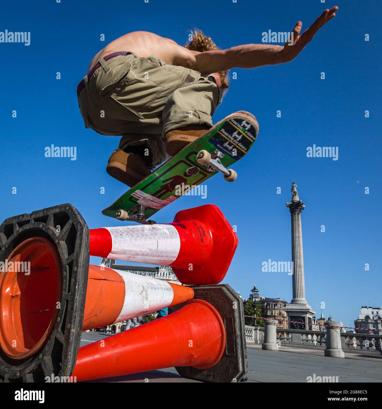 Un skateboarder survole des cônes dans Trafalgar Square. Banque D'Images