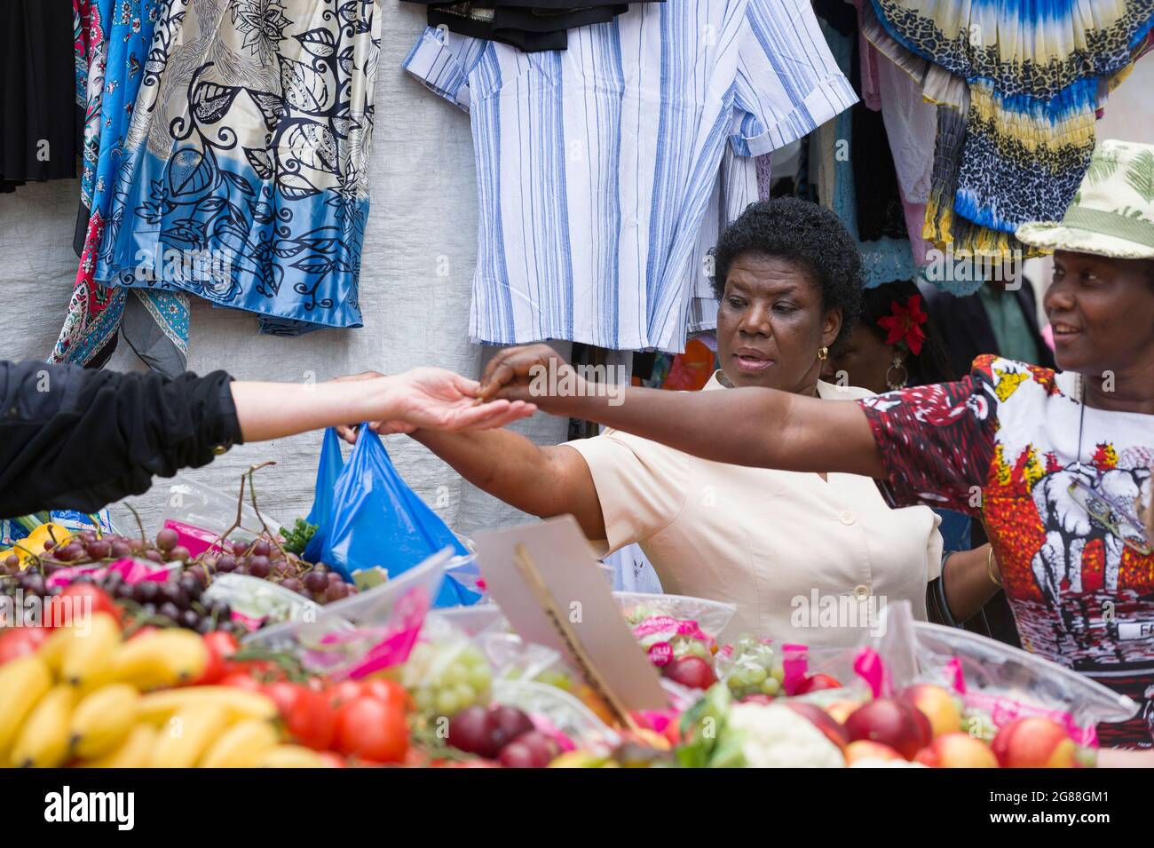 Une femme noire qui fait ses courses dans un stand de fruits et légumes, marché de Brixton, Londres, Royaume-Uni. 8 août 2009 Banque D'Images
