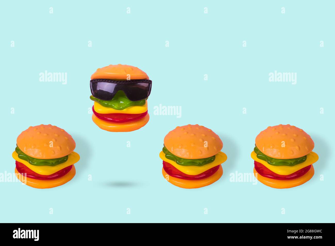 Idée créative faite à partir d'un hamburger avec des lunettes de soleil qui  est placé dans une rangée avec des hamburgers normaux. Concept de  nourriture drôle minimale. Soyez différent. Minimum juin Photo