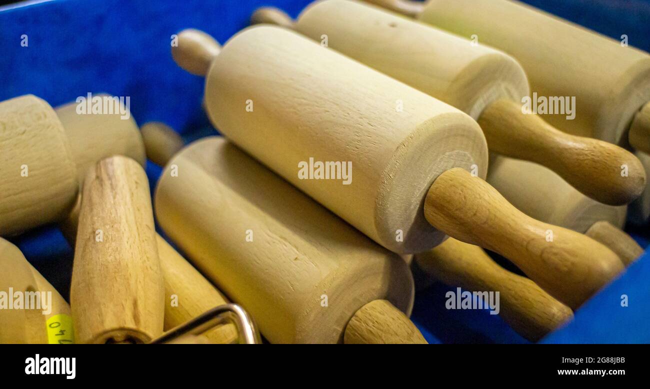 plusieurs épingles à roulettes en bois dans une cabine vendant des produits ménagers sur un marché régional Banque D'Images