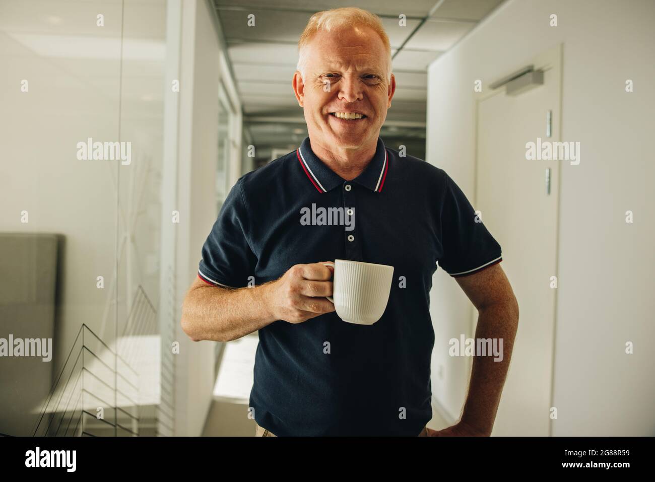 Portrait d'un cadre supérieur heureux prenant un café au travail. homme d'affaires ayant une pause café au travail. Banque D'Images