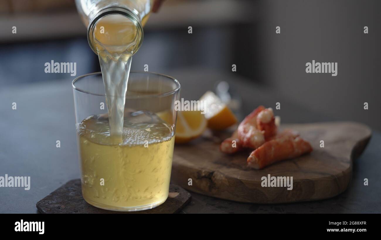 Verser la bière au gingembre dans un verre à verre avec pattes de crabe sur fond, photo large Banque D'Images