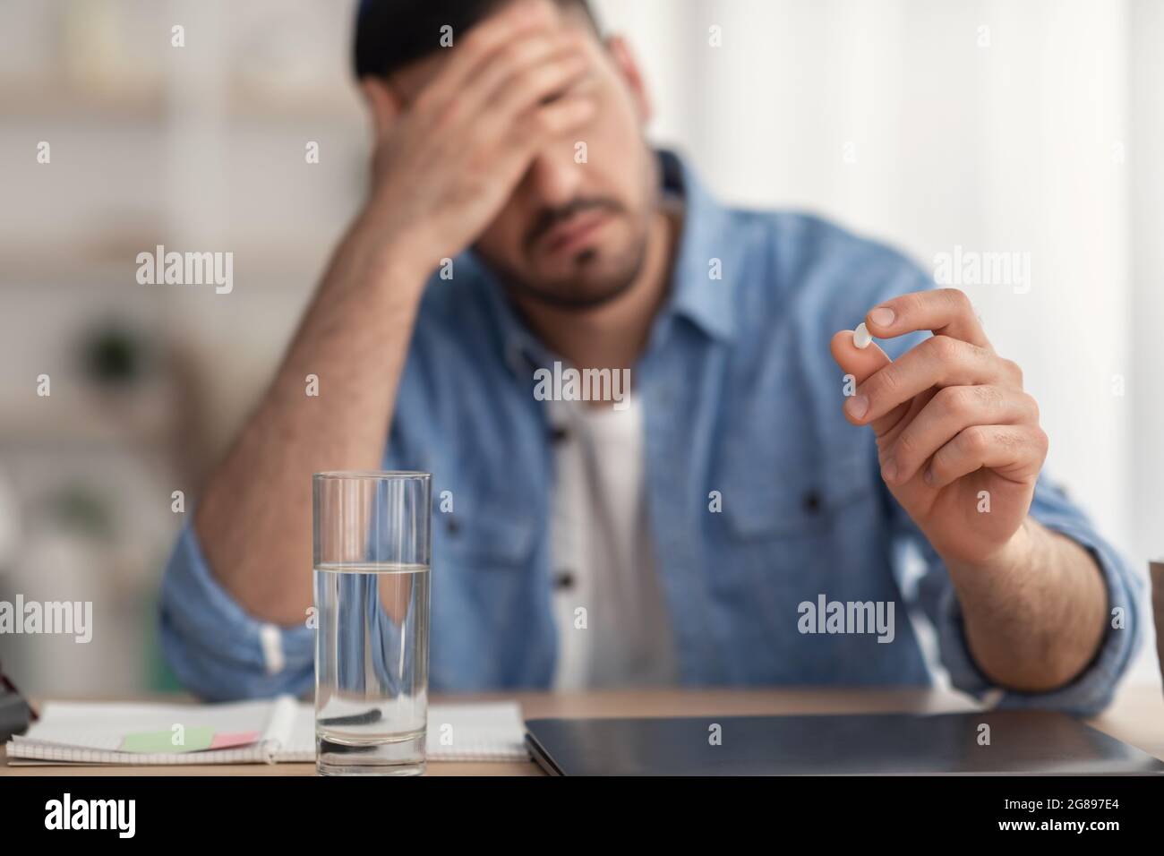 Malade méconnaissable Homme prenant des pilules de maux de tête Banque D'Images