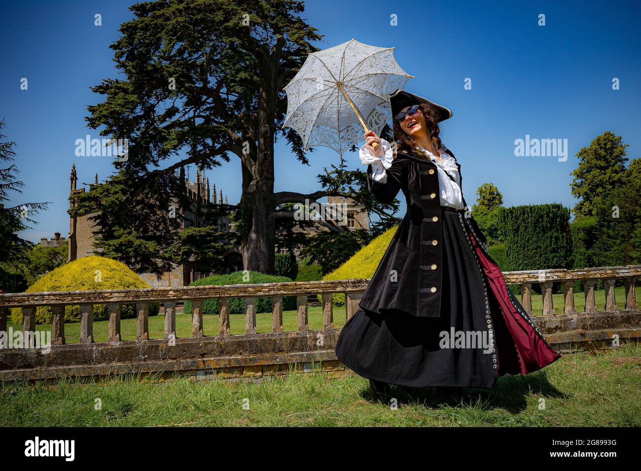 Kindra Jones utilise un parasol pour se protéger du soleil en affichant son costume de piraticule à Fantasy Forest, un festival en plein air au château de Sudeley à Cheltenham, Qui reste le seul château privé d'Angleterre à avoir une reine enterrée dans le domaine - la reine Katherine Parr, la dernière et la survie de la femme du roi Henri VIII - qui a vécu et est mort dans le château. Date de la photo: Dimanche 18 juillet 2021. Banque D'Images