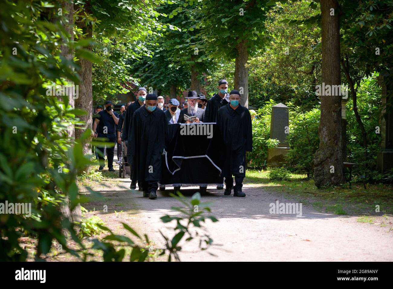 Hambourg, Allemagne. 18 juillet 2021. Le cercueil d'Esther Bejarano est conduit à travers le cimetière jusqu'à sa tombe dans une procession funéraire dirigée par le rabbin d'État Shlomo Bistritzky (4ème de droite) et son fils Joram Bejarano (5ème de droite). Le survivant du camp de concentration, Esther Bejarano, a été enterré dimanche au cimetière juif de Hambourg-Ohlsdorf. Credit: Jonas Walzberg/dpa/Alay Live News Banque D'Images