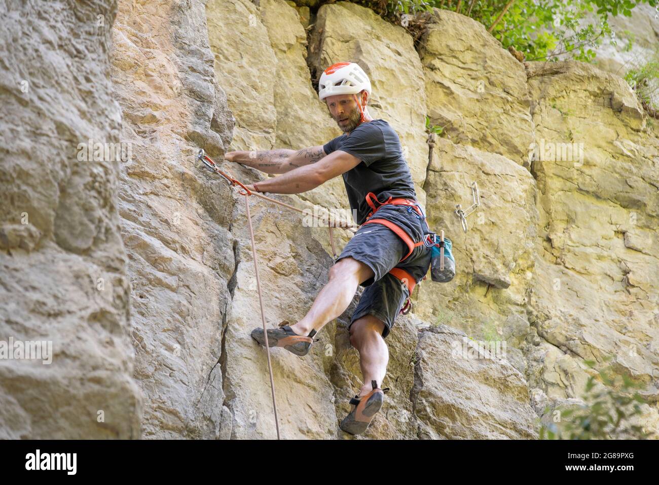 Homme sportif de milieu d'âge lors d'une difficile excursion d'escalade dans la zone d'escalade de la Gola, vallée de la Sarca, montagnes du lac de Garde, Trentin Italie Banque D'Images