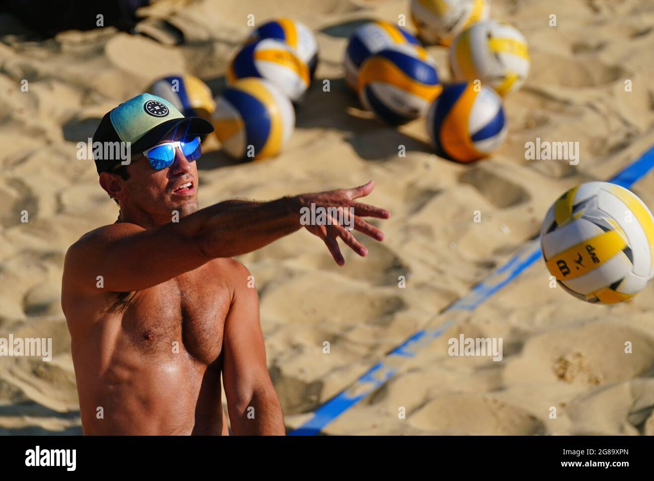 Un homme jouant du volley-ball sur la plage de Brighton à East Sussex. Le jour le plus chaud de l'année a été enregistré samedi dans les quatre nations du Royaume-Uni et les prévisionnistes estiment qu'il pourrait être encore plus chaud dimanche. Date de la photo: Dimanche 18 juillet 2021. Banque D'Images