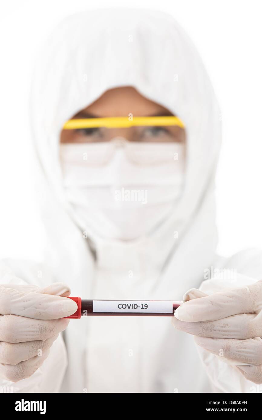 Un scientifique stérilise un tissu de blouse de laboratoire tenant l'échantillon de tube à essai Covid-19 en main. Accent sélectif sur le nom du virus. Concept pour les médecins essayer Banque D'Images