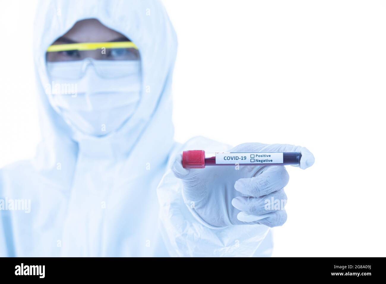 Un scientifique stérilise un tissu de blouse de laboratoire tenant l'échantillon de tube à essai Covid-19 en main. Accent sélectif sur le nom du virus. Concept pour les médecins essayer Banque D'Images