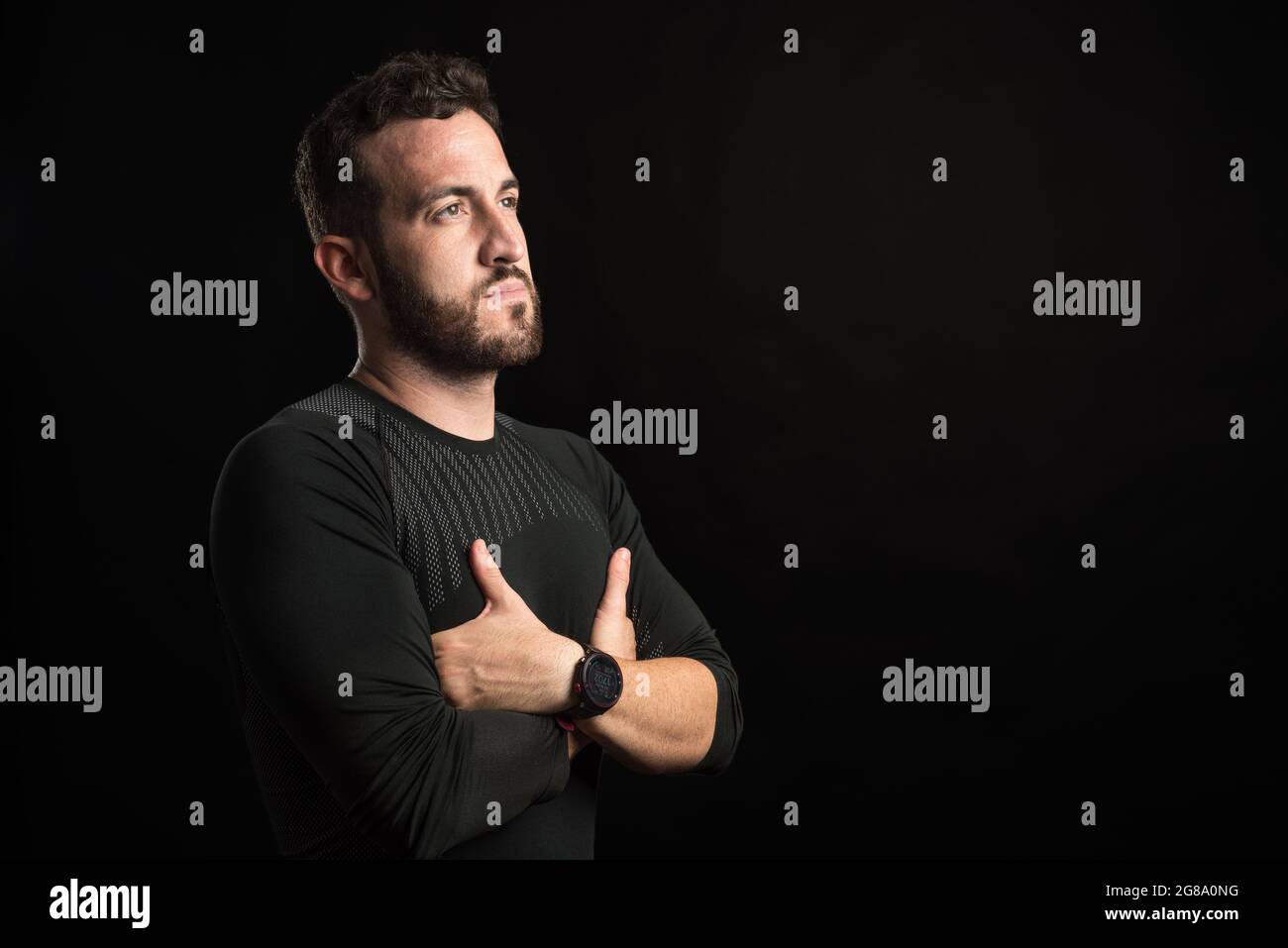 Portrait d'un homme adulte avec les bras croisés regardant sur le côté Banque D'Images